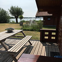 Het terras met picknicktafel aan de buitenzijde van de trekkershut op de camping